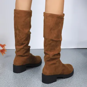 Close-up view showing the slouchy design and textured suede of brown mid-calf boots.