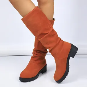 Slouchy orange suede mid-calf boots for women featuring a chunky block heel and lug sole.