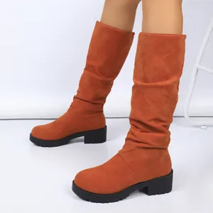 Detailed view of women's orange faux suede slouchy boots with chunky black heels