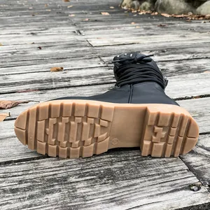 Macro view of the durable gum-colored lug sole on a black studded mid-calf boot