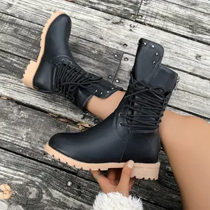 Detailed macro view of black mid-calf combat boots with silver studs and side zipper