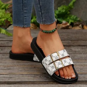 Gedetailleerd beeld van witte bloemen slippers met dubbele verstelbare gespen.