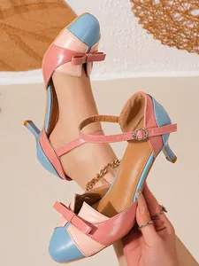 Close-up of stylish color-block heeled sandals with elegant bow detail and ankle strap