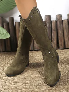 Close-up detail of olive green suede western cowboy boots with silver studs