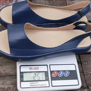 Detail view of navy blue peep-toe flat sandals showing weight of 251g on a scale.