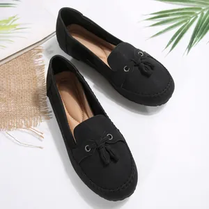 Detail view of black women's loafers featuring a classic tassel bow and soft cushioned insole.