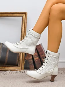 Gros plan de bottines blanches à lacets de style victorien avec texture de dentelle