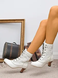 Vue détaillée de bottines à lacets blanches à petit talon ornées de motifs de dentelle chic