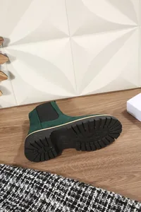 Dettaglio di uno stivale Chelsea verde scuro con suola carrarmato nera e punta rotonda