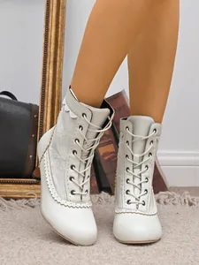Vue détaillée de bottines à petits talons blanches avec laçage élégant et bords festonnés chic
