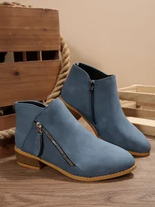 Detail shot of blue faux suede ankle boots featuring stylish double side zipper accents