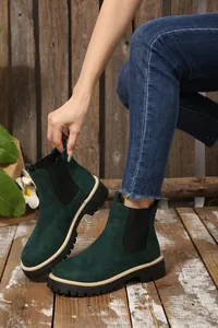 Primo piano di stivaletti Chelsea da donna in camoscio verde scuro con suola nera carrarmato
