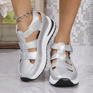 Detailed view of silver platform sandals with a hollow-out design and thick soles