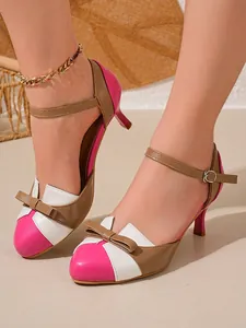 Close-up of color-blocked kitten heel sandals with bow detail and ankle strap