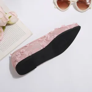 Detailed side and sole view of the pink lace flats with floral appliqués and grip.