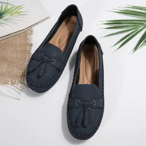 Detailed view of navy blue loafers with elegant tassel accents and a soft faux suede finish.