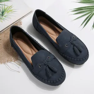 Close-up detail of navy blue suede tassel loafers with quilted tan comfort insole