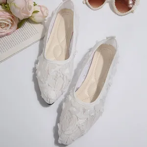 Close-up detail of elegant white lace mesh flat shoes featuring romantic 3D floral accents