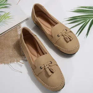 Detail of khaki women's loafers with elegant tassel embellishment and stitching.