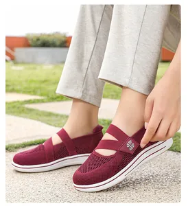 Detailed view of maroon breathable fly-knit mesh walking shoes for women worn outdoors