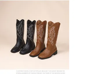 Detailed side view showing black and brown embroidered Western cowboy boots with chunky heels