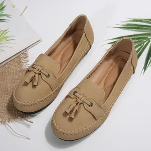 Detailed view of khaki women's slip-on loafers with decorative tassels and stitching