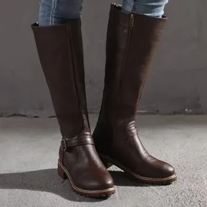 Detail showing texture of brown tall riding boots with side zipper and ankle buckle.