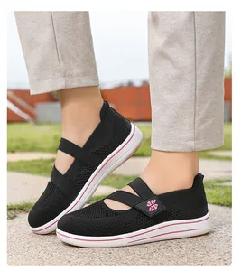 Side view of women's breathable black mesh slip-on walking shoes in outdoor setting
