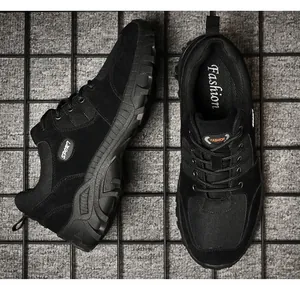 Close-up detail of durable black men's outdoor hiking shoes on a textured grid