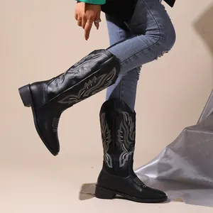 Close-up of black embroidered western cowboy boots with V-cut and chunky heel.