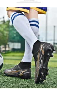 Detailed view of high-top soccer cleats showing firm ground studs and flame design patterns