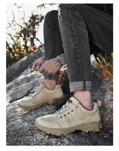 Close-up of durable low-top men's khaki hiking shoes being tied on a rocky outdoor trail