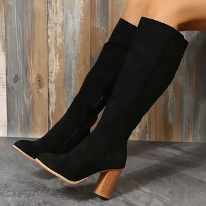 Detailansicht schwarzer Overknee-Stiefel aus Wildleder mit klobigem Absatz in Holzoptik.
