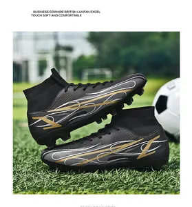 Close-up profile of high-top black soccer cleats with gold streaks on a green pitch