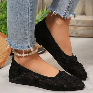 Elegant black lace pointed-toe flat shoes with 3D floral texture shown on model feet