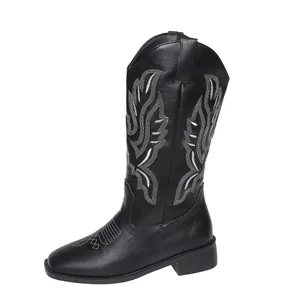 Detailed side profile of a black western cowboy boot featuring intricate white embroidery
