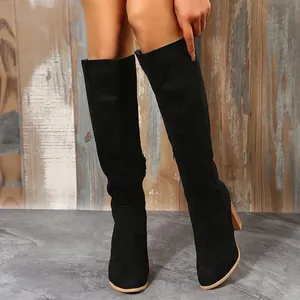 Modische schwarze Overknee-Stiefel aus Wildlederimitat mit klobigem Absatz an einem Model.