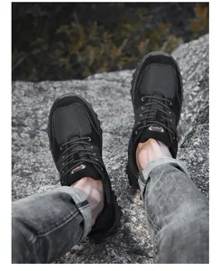 Detail view of durable black low-top hiking shoes for men worn on a rocky outdoor terrain