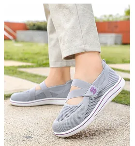 Close-up view of grey breathable knit slip-on walking shoes with purple elastic straps.