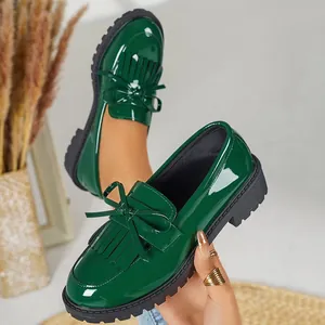 Elegant dark green patent leather loafers featuring a classic bow and fringe detail