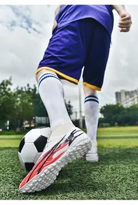 Detail shot of high-top knitted soccer shoes for professional training on grass field