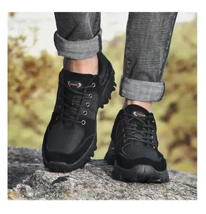 Detailed view of black low-top hiking shoes for outdoor trekking on rocky terrain rocks