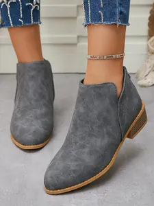 Detail view of grey pointed-toe ankle boots with chunky heel and side cutout