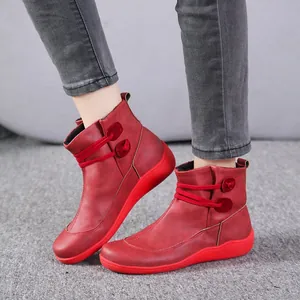 Detailansicht roter Vintage-Stiefeletten mit Zierknöpfen und dicken roten Sohlen.