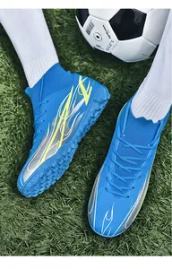 Close-up detail of blue high-top soccer cleats with fly-knit ankle on green grass