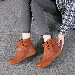 Detailansicht brauner Retro-Stiefeletten aus Leder mit dekorativen Schnürungen am Modell.