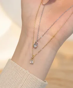 Detailed close-up of two S925 sterling silver lock pendant necklaces in gold and silver