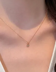 Macro detail of minimalist 14K gold plated S925 silver lock pendant necklace worn by model