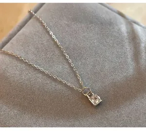 Close-up of S925 silver necklace with sparkling single diamond lock pendant