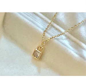 Detail view of S925 silver padlock necklace featuring a clear stone, 14K gold plated.